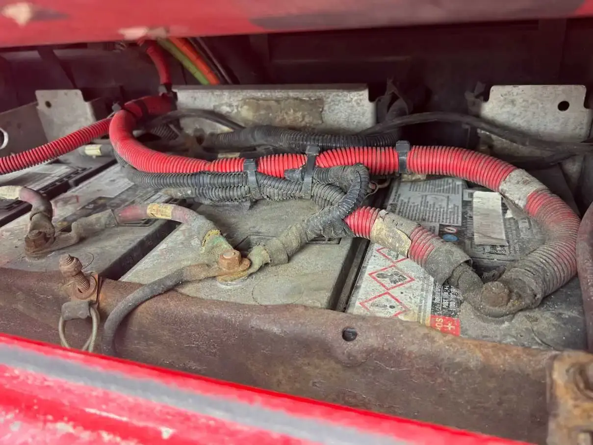 The battery box of a red truck opened for service