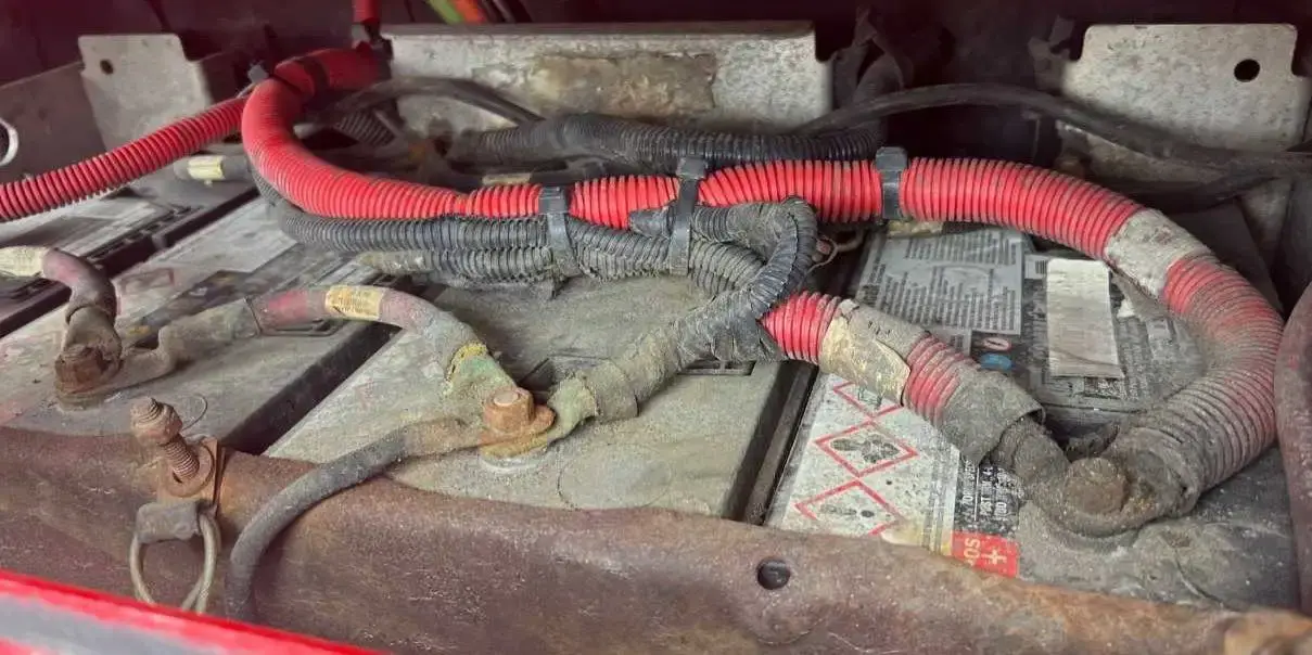 An opened battery box with cables and terminals exposed