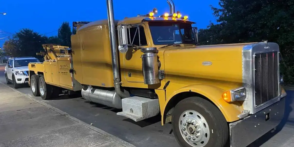 The Tri City wrecker hitched to a vehicle after dark