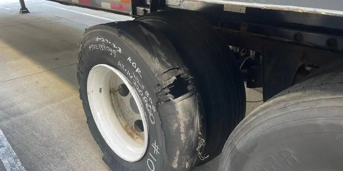 A shredded trailer tire stripped back to the casing