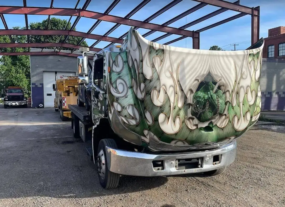 A custom-painted truck loaded on a flatbed in the Tri City yard